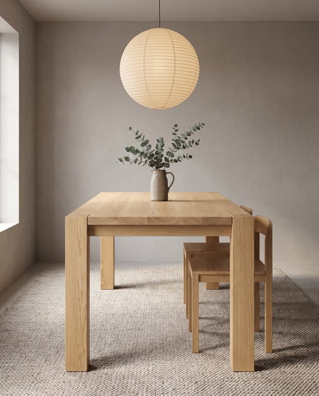 The Balkan Dining Table in a quiet Japandi dining room, a paper lantern and eucalyptus