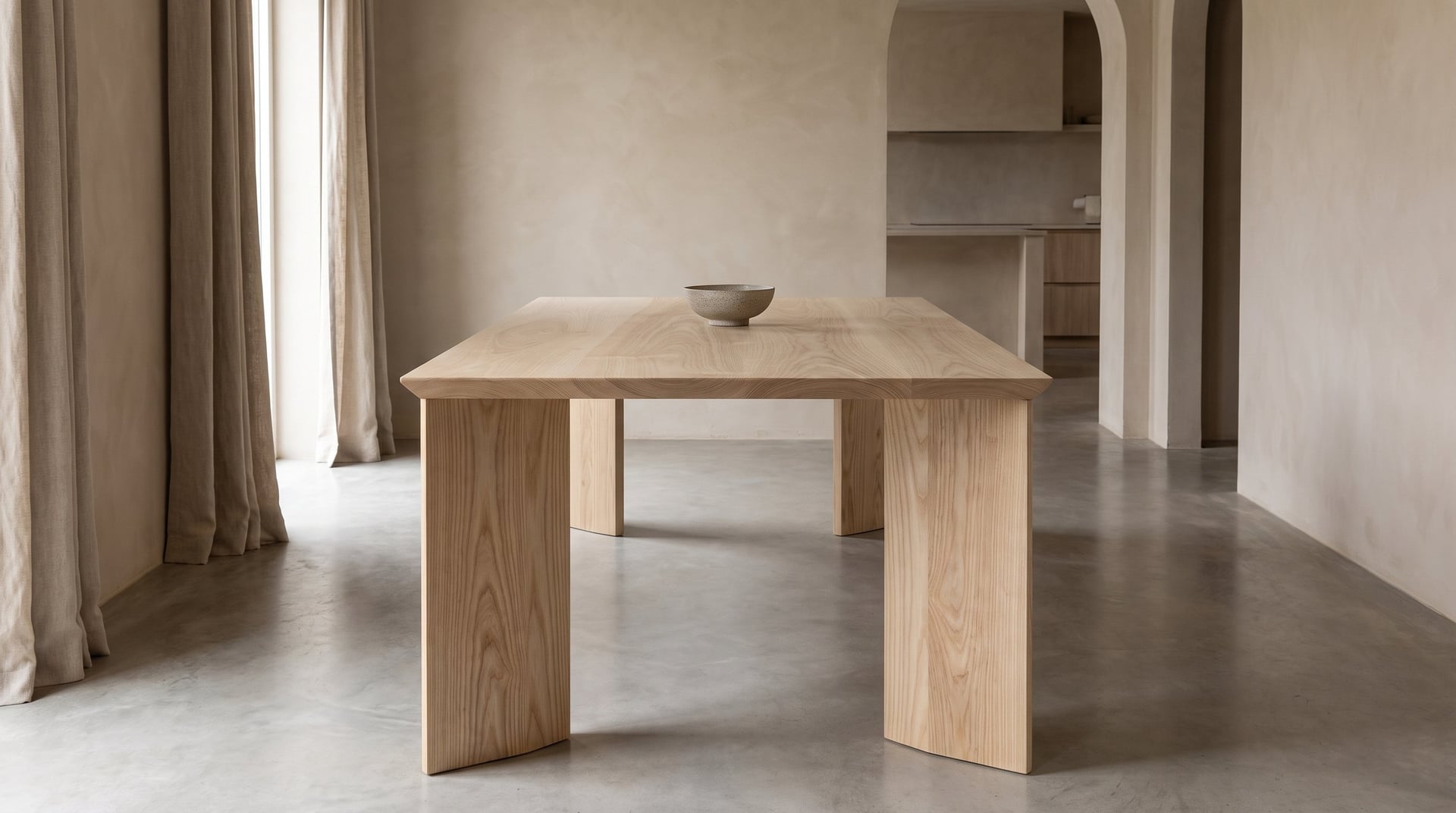 Kouper Dining Table in ash, seen from the end, the splayed diamond-section legs