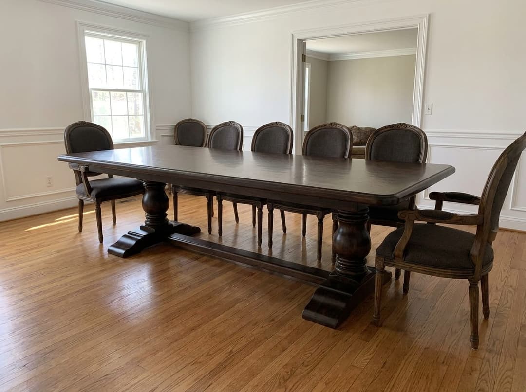 Traditional espresso moabi refectory table with turned columns, sled feet and wedged stretcher in a wainscoted dining room