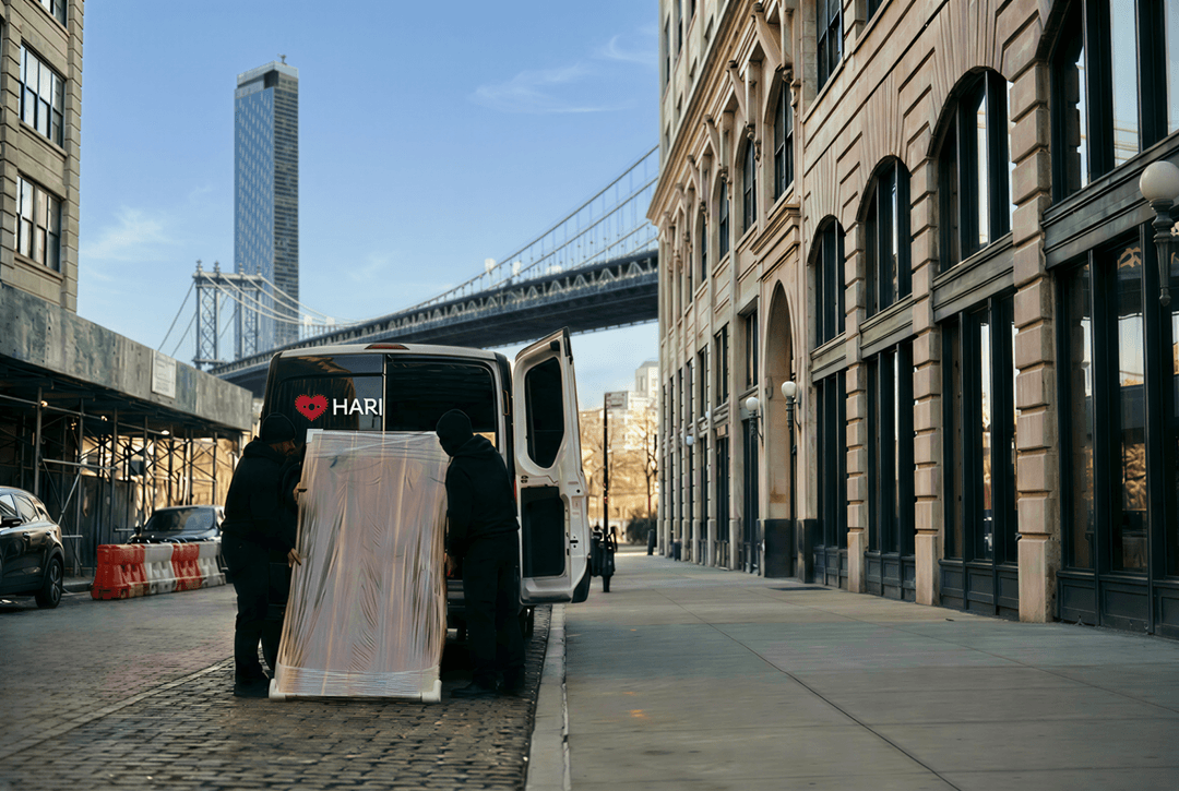 Coordinated delivery of protected walnut tables being unloaded at a Brooklyn waterfront building