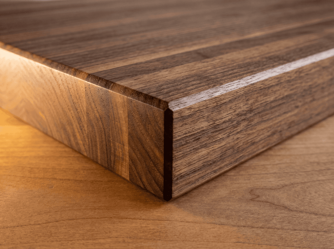 Macro of a solid walnut shelf corner — continuous grain through the full thickness