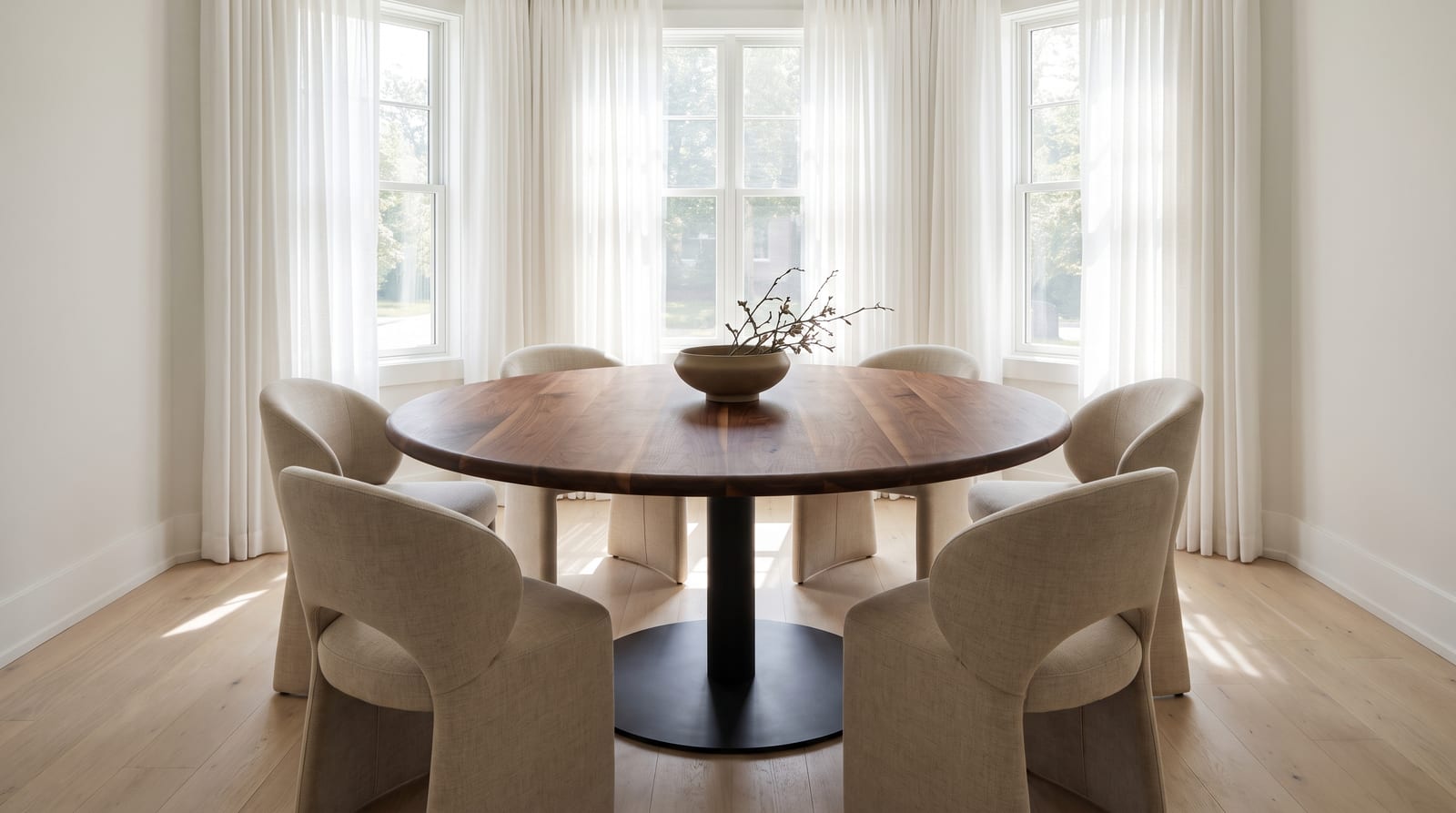 Solid walnut round tabletop, face grain — a sunlit dining room, 60-inch round walnut table on a black pedestal